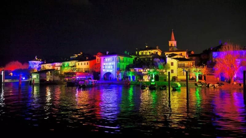 Isola dei Pescatori illuminata di notte, riflessi sul Lago Maggiore
